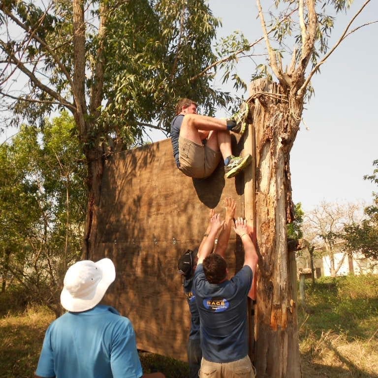 OBSTACLE COURSE Man climbing wooden structure